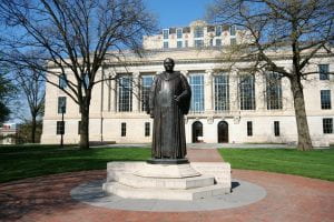 A large bronze statue of William Oxley Thompson. Behind it is the Thompson Library at OSU.